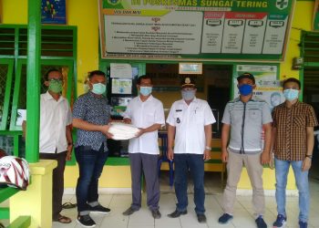 Kades Sungai Tering Dampingi Ketua LMPP Tanjabtim Serahkan Baju APD di Puskesmas