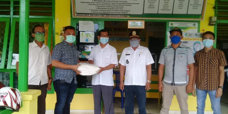Kades Sungai Tering Dampingi Ketua LMPP Tanjabtim Serahkan Baju APD di Puskesmas